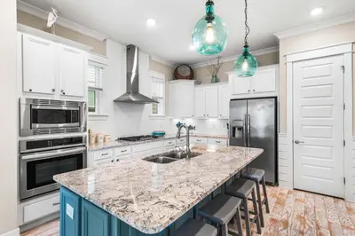 a kitchen with white cabinets and a granite counter top at Restfull Dwelling in Inlet Beach