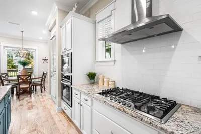 a kitchen with white cabinets and a stove top oven at Restfull Dwelling in Inlet Beach