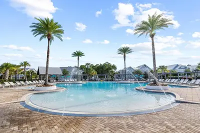 a large pool with palm trees in a resort at Restfull Dwelling in Inlet Beach