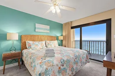 a bedroom with a bed with a view of the ocean at Commodore 0702 in Panama City Beach