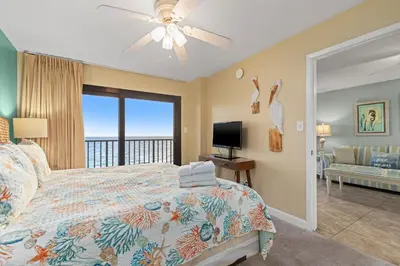 a bedroom with a bed with a view of the ocean at Commodore 0702 in Panama City Beach