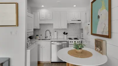 a kitchen with white cabinets and a table with a potted plant at Emerald Hill 23 - The Little Pearl in Santa Rosa Beach