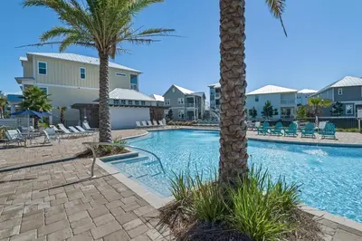 a swimming pool with palm trees and condos at Prominence B - 30 Ray in Inlet Beach
