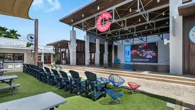 a group of chairs and tables in front of a building at Prominence B - 30 Ray in Inlet Beach