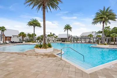 a swimming pool with palm trees in a resort at Prominence B - 30 Ray in Inlet Beach