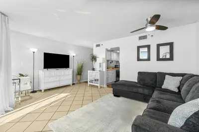 a living room with a couch and a flat screen tv at Sunbird of Panama City Beach 503E in Panama City Beach