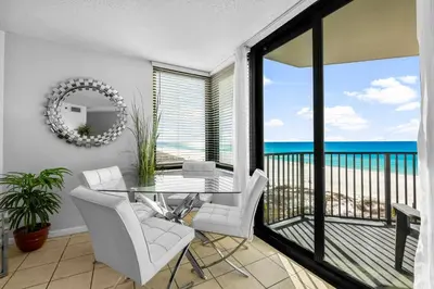 a dining room with a view of the ocean at Sunbird of Panama City Beach 503E in Panama City Beach