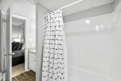a bedroom with a bed and a shower curtain at Sunbird of Panama City Beach 503E in Panama City Beach