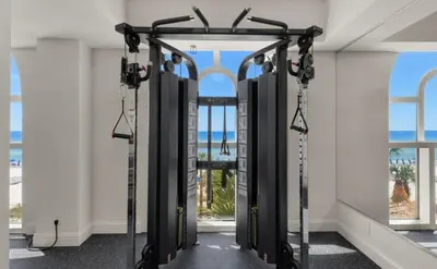 a row of treadmills in a room with windows at The Emerald Nest in Panama City Beach