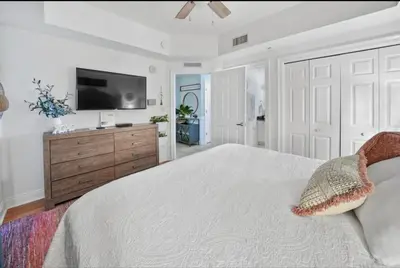 a bedroom with a bed and a tv on a wall at The Emerald Nest in Panama City Beach