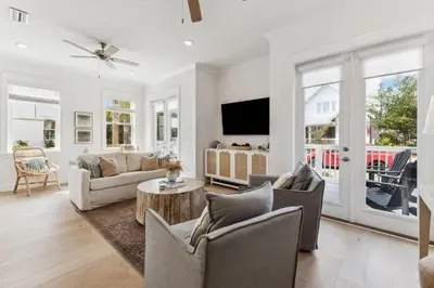 a living room with a couch and chairs and a tv at Coastal Grace in Inlet Beach