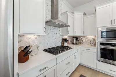 a kitchen with white cabinets and a stove top oven at Coastal Grace in Inlet Beach