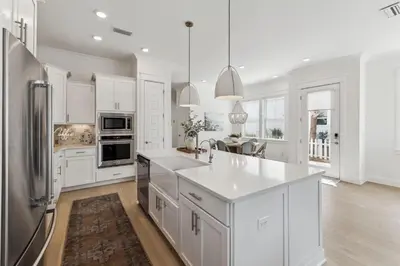 a kitchen with white cabinets and a stainless steel refrigerator at Coastal Grace in Inlet Beach