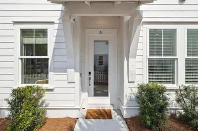 a white house with a white door and windows at Coastal Grace in Inlet Beach