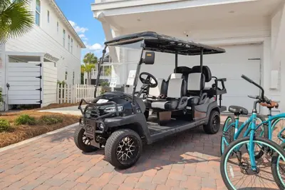 a golf cart parked in front of a house with bicycles at Coastal Grace in Inlet Beach