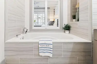 a bath tub with a window and a towel on it at Poolside Paradise in Inlet Beach