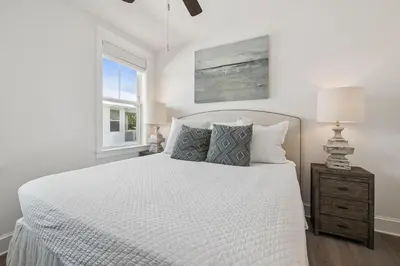 a white bedroom with a bed and a window at Our Oasis in Inlet Beach