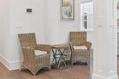 two wicker chairs and a stool in a room at Our Oasis in Inlet Beach