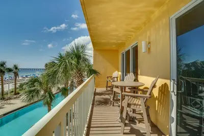 a balcony with a table and chairs and a view of the beach at Calypso 1-202 by Emerald Coast Retreats in Panama City Beach