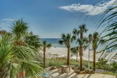 a view of a beach with palm trees and the ocean at Calypso 1-202 by Emerald Coast Retreats in Panama City Beach