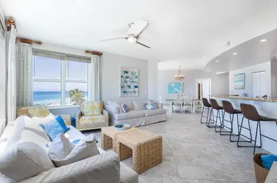 a living room with couches and a kitchen and a counter at Rare Corner-Unit at AQUA 201 Private Elevator, Multiple Balconies Sunset Views in Panama City Beach
