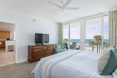 a bedroom with a bed and a tv and a balcony at Rare Corner-Unit at AQUA 201 Private Elevator, Multiple Balconies Sunset Views in Panama City Beach