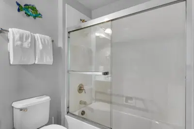 a bathroom with a shower with a glass door at Aqua 0309 in Panama City Beach