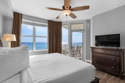 a bedroom with a bed and a flat screen tv at Aqua 0309 in Panama City Beach