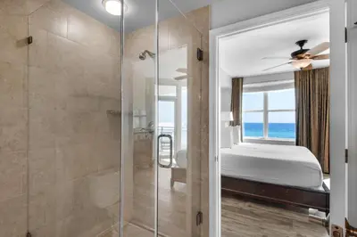 a bathroom with a shower and a bedroom with a bed at Aqua 0309 in Panama City Beach