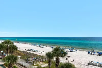 a view of a beach with palm trees and the ocean at Aqua 0309 in Panama City Beach