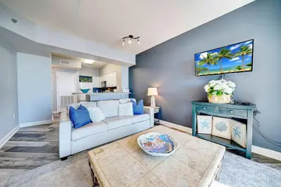 a living room with a couch and a table at Beach Please in Panama City Beach