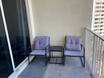 two chairs and a table on a balcony at Beach Please in Panama City Beach