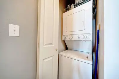 a kitchen with a refrigerator and a washer and dryer at Beach Please in Panama City Beach