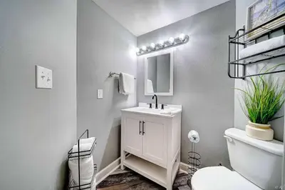 a bathroom with a sink and a toilet and a mirror at Beach Please in Panama City Beach