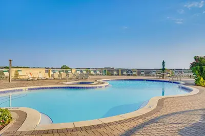 a large swimming pool with a brick walkway around it at Scenic Balcony and Resort Perks PCB Condo! in Panama City Beach