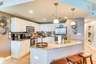 a kitchen with white cabinets and a large island at Scenic Balcony and Resort Perks PCB Condo! in Panama City Beach