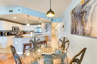 a dining room and kitchen with a glass table and chairs at Scenic Balcony and Resort Perks PCB Condo! in Panama City Beach