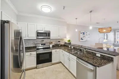a kitchen with white cabinets and stainless steel appliances at FL(S) - The Oxford - 10343 E Co Hwy 30A Unit 410 in Inlet Beach