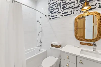a bathroom with a toilet and a sink and a mirror at Salt & Light in Santa Rosa Beach