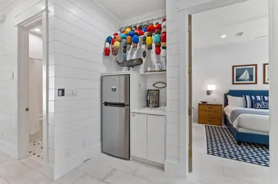 a kitchen with a refrigerator and a bed in a room at Salt & Light in Santa Rosa Beach