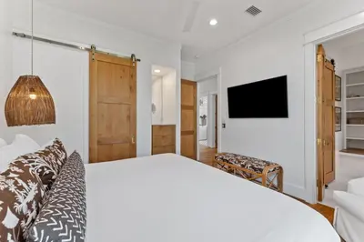 a bedroom with a white bed and a tv at Salt & Light in Santa Rosa Beach