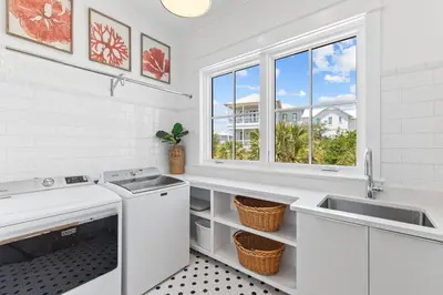 a white kitchen with two sinks and a window at Salt & Light in Santa Rosa Beach