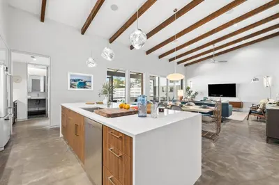a kitchen with white countertops and a living room at Seagrove Surf Shack in Santa Rosa Beach