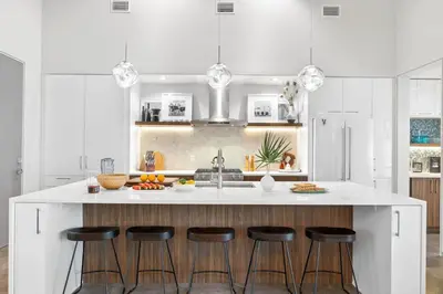 a kitchen with a large white island with bar stools at Seagrove Surf Shack in Santa Rosa Beach