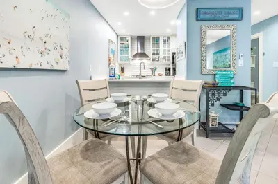 a dining room with a glass table and chairs at Somewhere in the Sun in Santa Rosa Beach