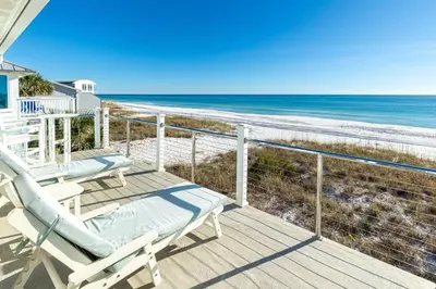 a deck with two chairs and the beach at Diamond Dunes in Inlet Beach