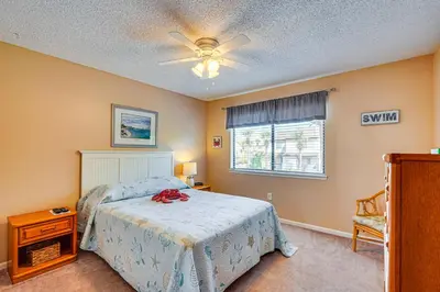 a bedroom with a bed and a ceiling fan at Walk to Shore PCB Home with Balcony and Pool Access! in Panama City Beach