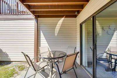 a glass table and chairs on a patio at Walk to Shore PCB Home with Balcony and Pool Access! in Panama City Beach