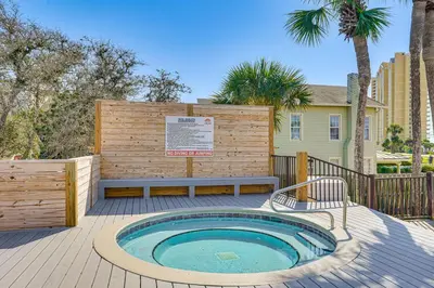 a hot tub on a deck with a bench at Walk to Shore PCB Home with Balcony and Pool Access! in Panama City Beach