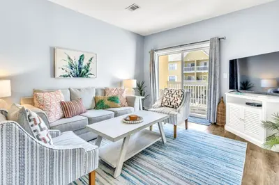 a living room with a couch and a tv at Coastside in Santa Rosa Beach